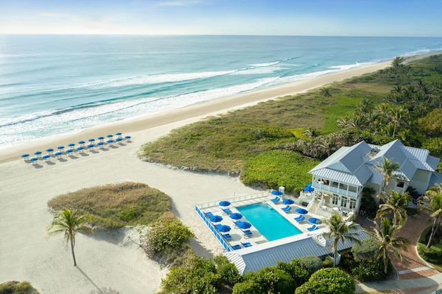 birds eye view of property with a water view and a view of the beach