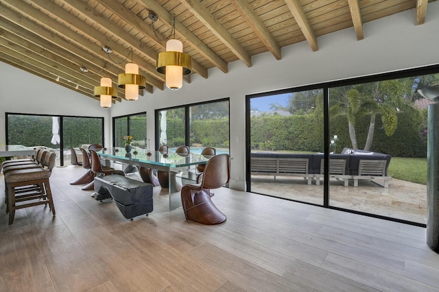 sunroom / solarium with lofted ceiling with beams, a wealth of natural light, and wood ceiling