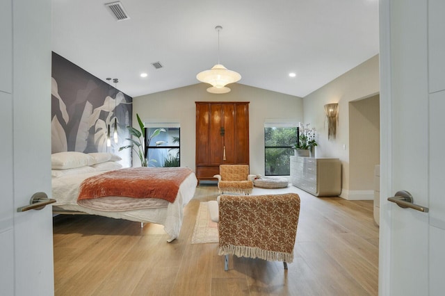 bedroom featuring light wood-style floors, lofted ceiling, visible vents, and baseboards