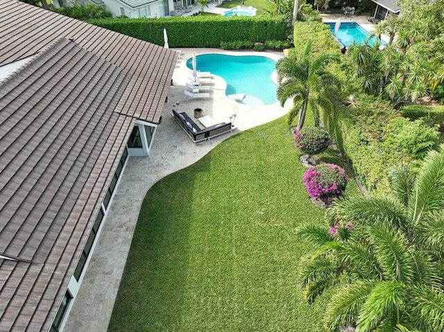 view of pool with a lawn and a patio