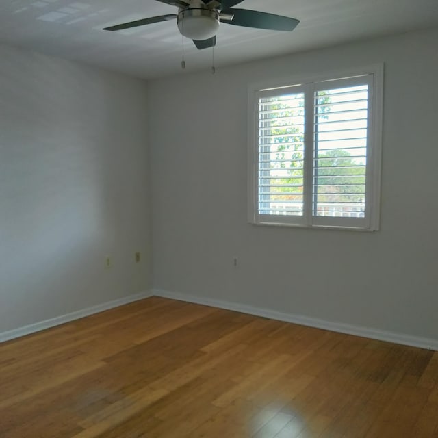 empty room with light wood finished floors, baseboards, and ceiling fan