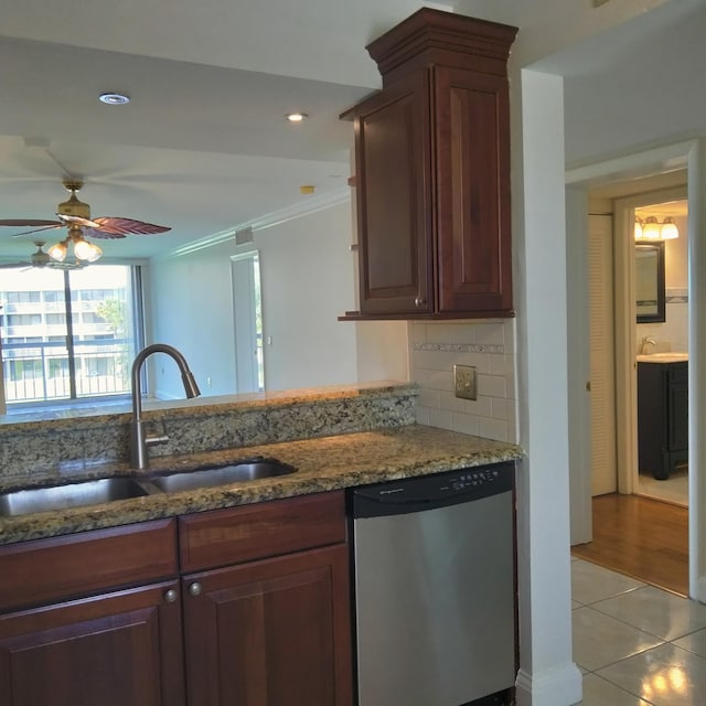 kitchen featuring a ceiling fan, stone counters, light tile patterned flooring, a sink, and stainless steel dishwasher