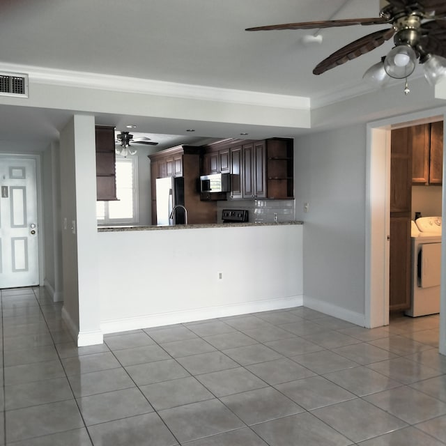 kitchen featuring a ceiling fan, open shelves, ornamental molding, stainless steel appliances, and washer and clothes dryer