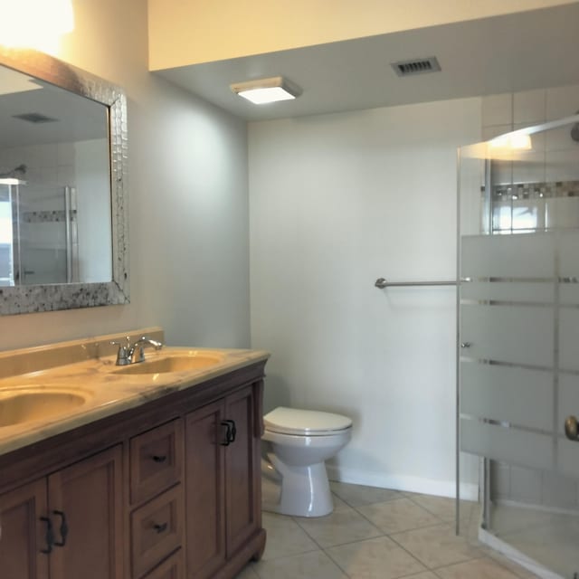 full bath featuring visible vents, toilet, a sink, a shower stall, and tile patterned flooring