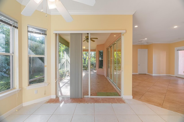 doorway with light tile patterned floors, ceiling fan, and crown molding