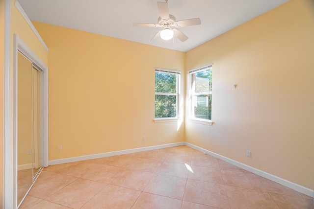 tiled spare room featuring ceiling fan