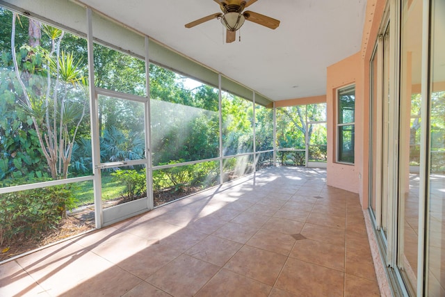 unfurnished sunroom featuring ceiling fan and plenty of natural light