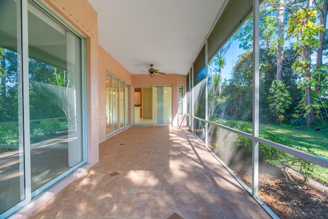 unfurnished sunroom with ceiling fan and plenty of natural light