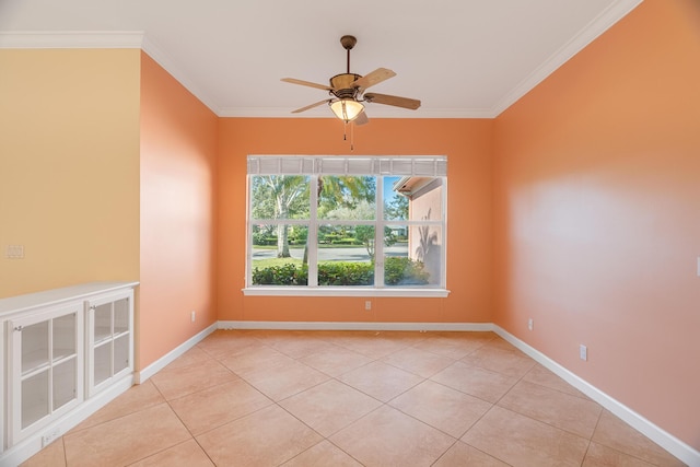 tiled empty room with ceiling fan and crown molding