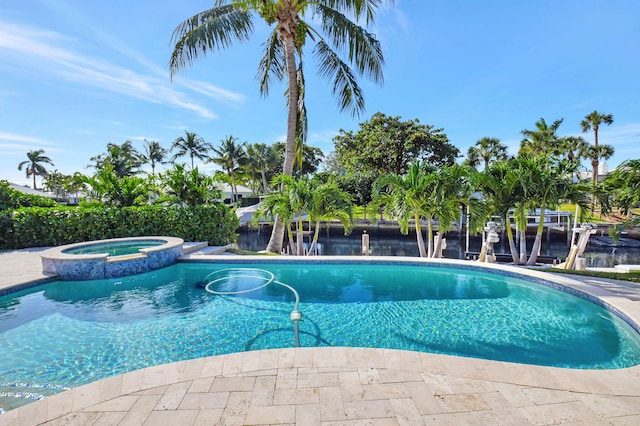 view of pool with an in ground hot tub and a water view