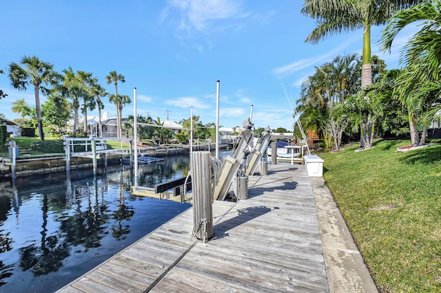 dock area with a lawn and a water view