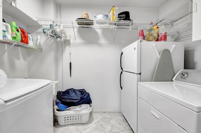 850 Holly Ln, Boca Raton, FL 33486 - washroom with baseboards, marble finish floor, washer and clothes dryer, and laundry area