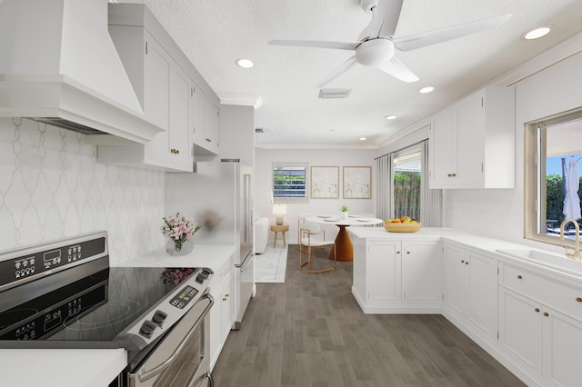 kitchen featuring sink, stainless steel electric stove, white cabinets, custom exhaust hood, and ornamental molding