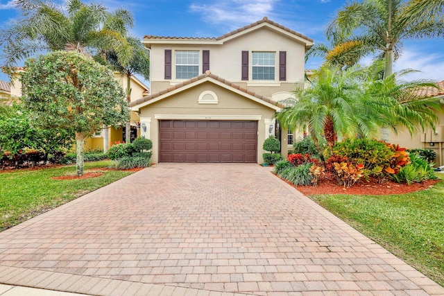 mediterranean / spanish house with a garage and a front lawn