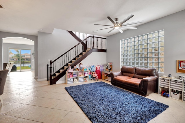 tiled living room featuring a healthy amount of sunlight and ceiling fan