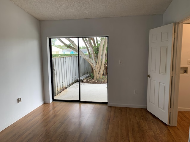 empty room featuring dark hardwood / wood-style flooring and a textured ceiling