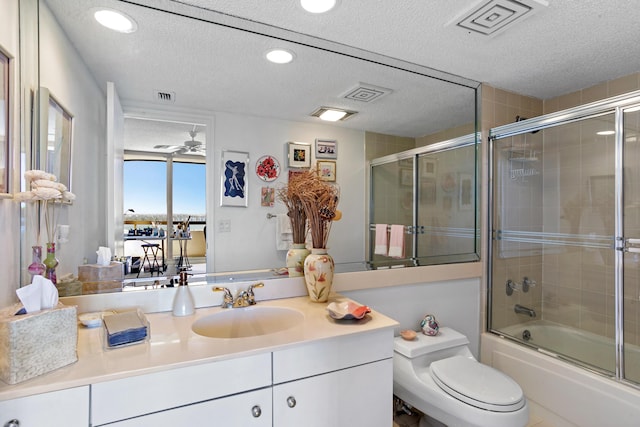 full bathroom featuring vanity, ceiling fan, toilet, and a textured ceiling