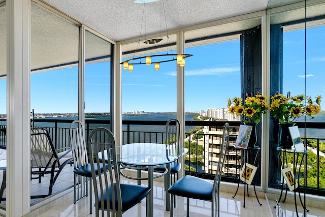 sunroom / solarium featuring a water view and a healthy amount of sunlight