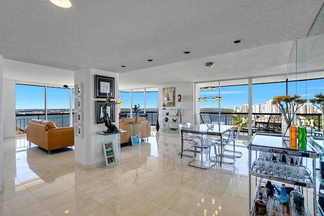 dining space with floor to ceiling windows, a wealth of natural light, and a water view