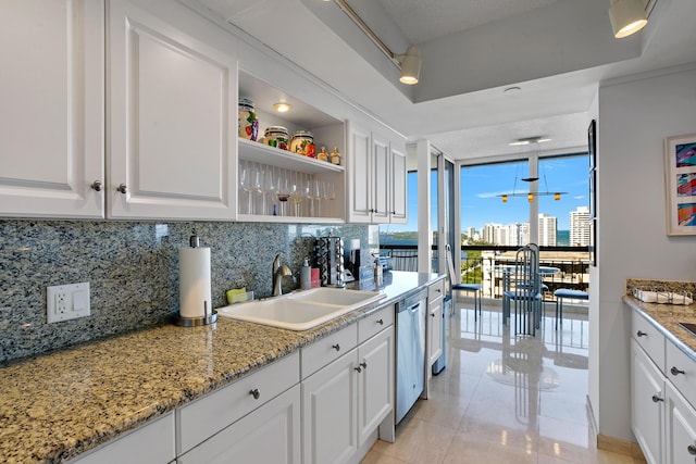 kitchen featuring light stone countertops, dishwasher, sink, decorative backsplash, and white cabinets