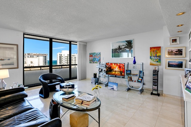 living room with a textured ceiling and a wall of windows