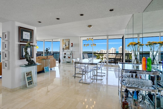 tiled dining room with expansive windows and a textured ceiling