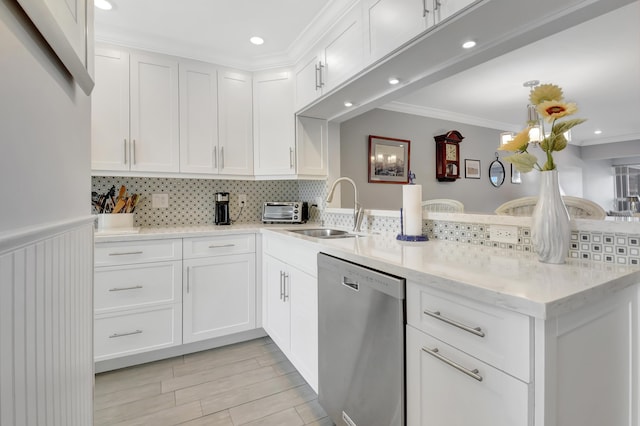 kitchen featuring white cabinets, kitchen peninsula, stainless steel dishwasher, and sink