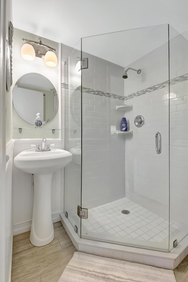 bathroom with hardwood / wood-style floors and a shower with door