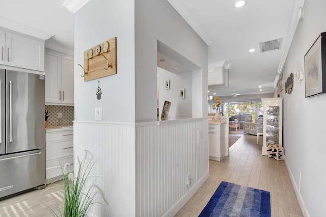 hall featuring light hardwood / wood-style flooring and ornamental molding