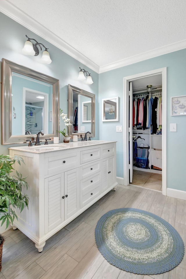 bathroom featuring crown molding, vanity, and a textured ceiling