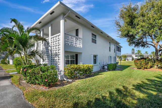 view of property exterior with a yard and cooling unit