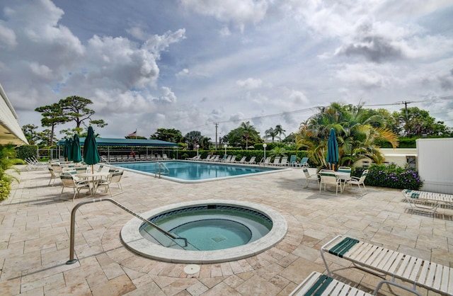 view of swimming pool featuring a community hot tub and a patio