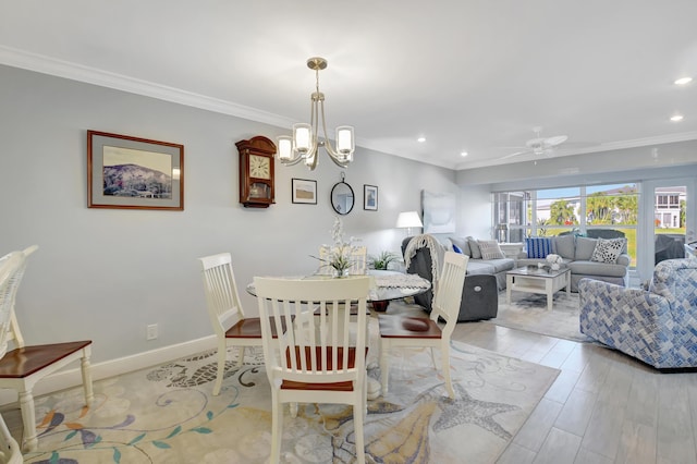 dining room featuring crown molding, light hardwood / wood-style floors, and ceiling fan with notable chandelier