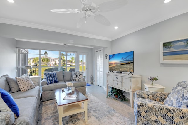 living room featuring ceiling fan, light hardwood / wood-style floors, crown molding, and a wealth of natural light