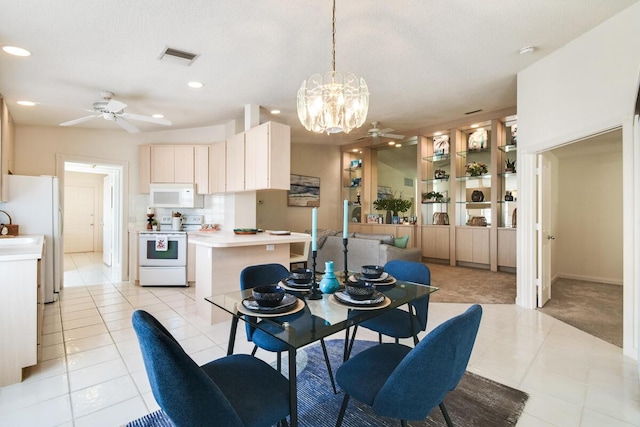 tiled dining room with sink, ceiling fan with notable chandelier, and a textured ceiling