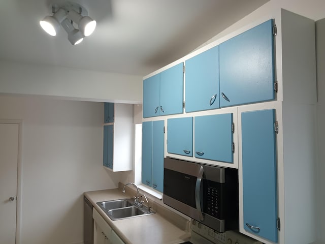 kitchen featuring sink, appliances with stainless steel finishes, and blue cabinets