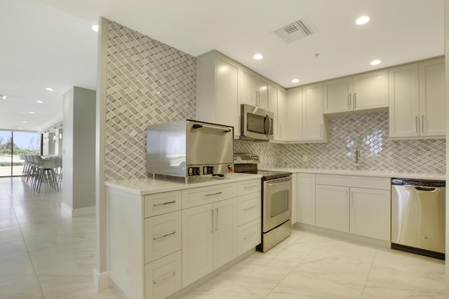 kitchen with appliances with stainless steel finishes, backsplash, and sink