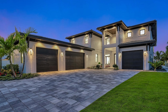 view of front of home featuring a garage and a lawn