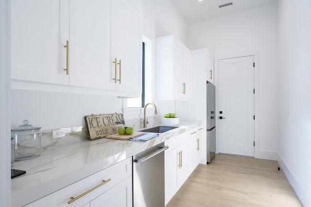 kitchen featuring light stone counters, white cabinetry, sink, and appliances with stainless steel finishes