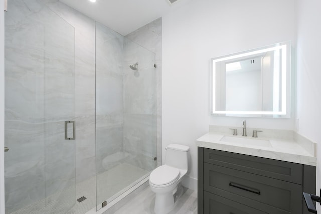 bathroom featuring vanity, a shower with shower door, and toilet