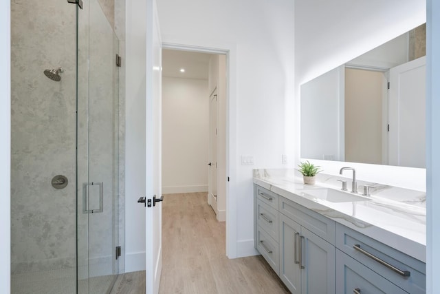 bathroom featuring wood-type flooring, vanity, and a shower with shower door