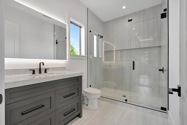 bathroom with toilet, vanity, and walk in shower