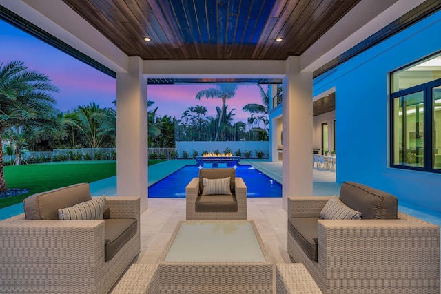 pool at dusk with a jacuzzi, a yard, and a patio area