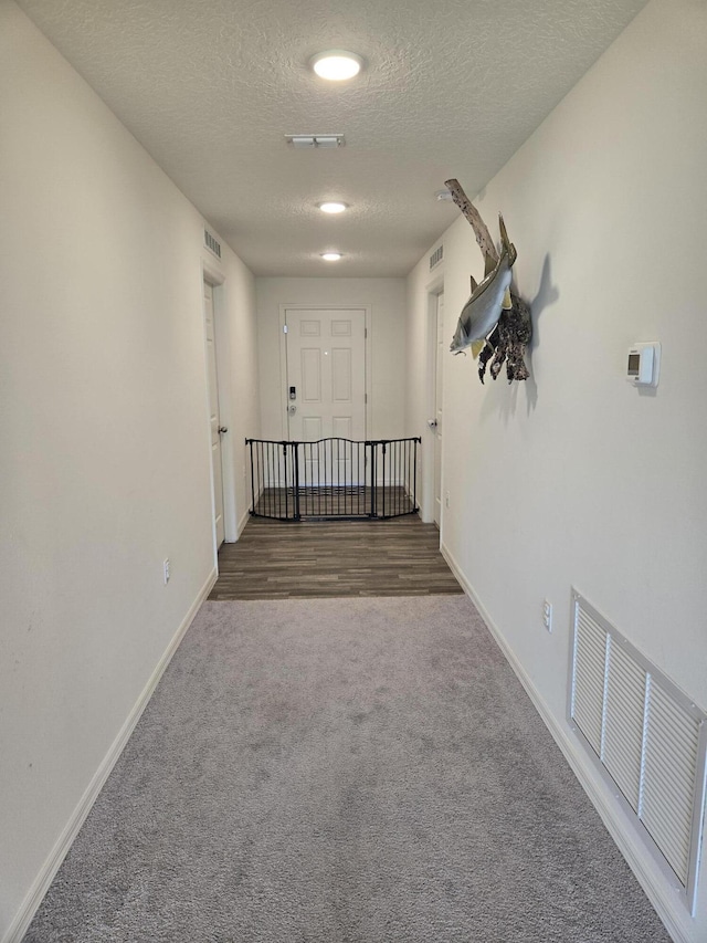 interior space featuring carpet flooring and a textured ceiling