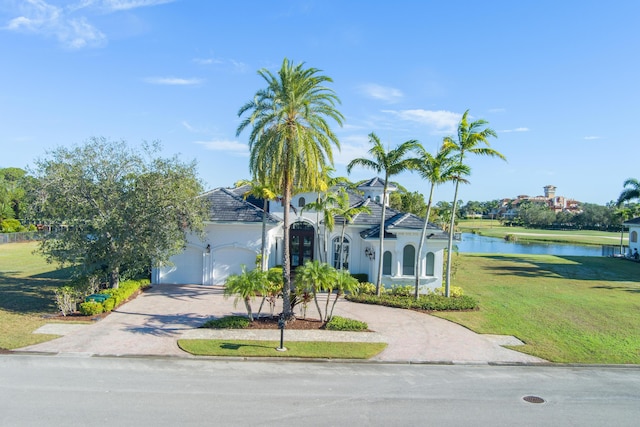 mediterranean / spanish-style house featuring a front yard, a water view, and a garage