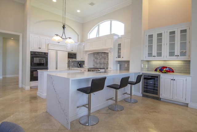 kitchen with paneled fridge, decorative light fixtures, white cabinetry, and wine cooler