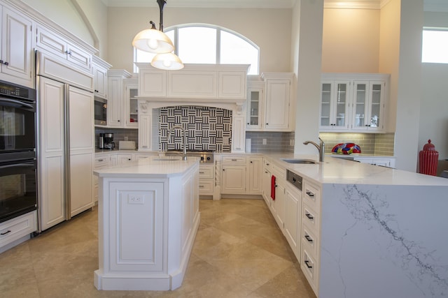 kitchen with sink, backsplash, kitchen peninsula, built in appliances, and decorative light fixtures