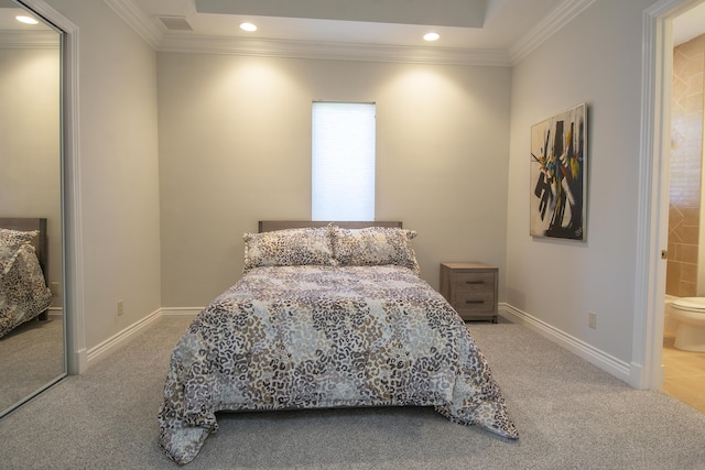 bedroom featuring carpet floors, crown molding, and connected bathroom