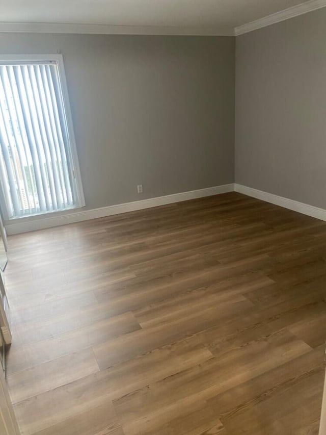 empty room featuring crown molding and hardwood / wood-style floors