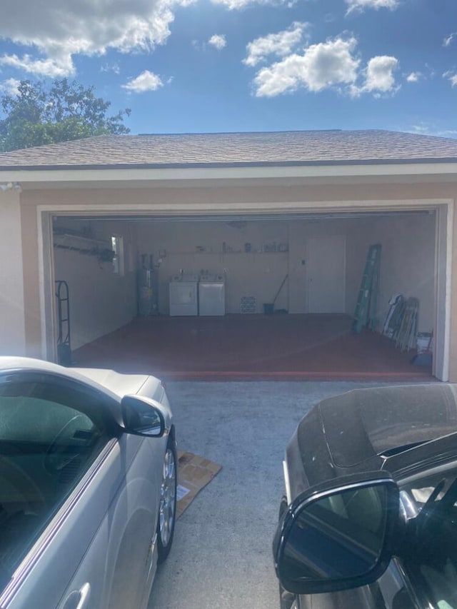 garage featuring washer and clothes dryer and electric water heater